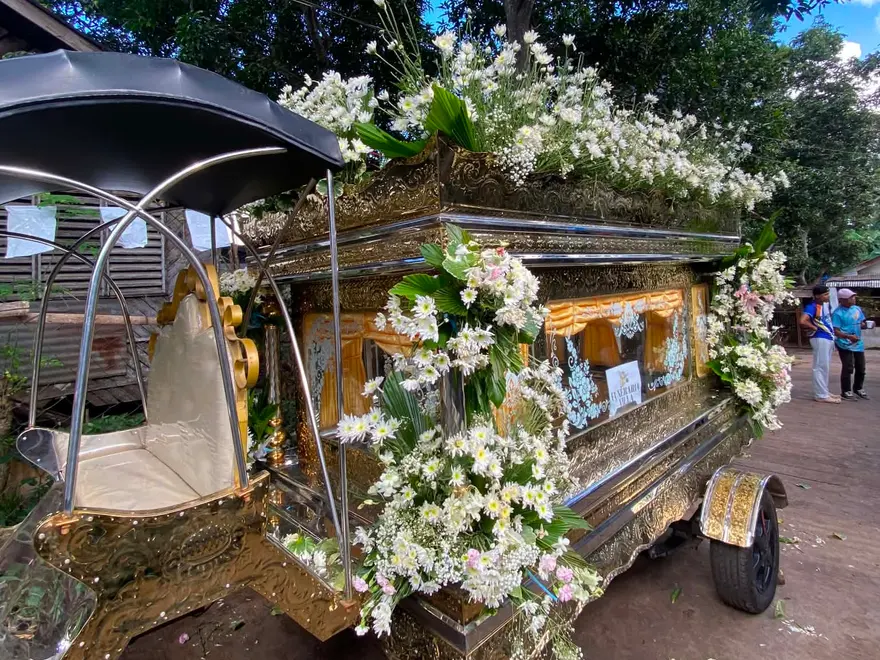 The office's funeral carriage (karwahe) with its gold casket compartment and white flowers